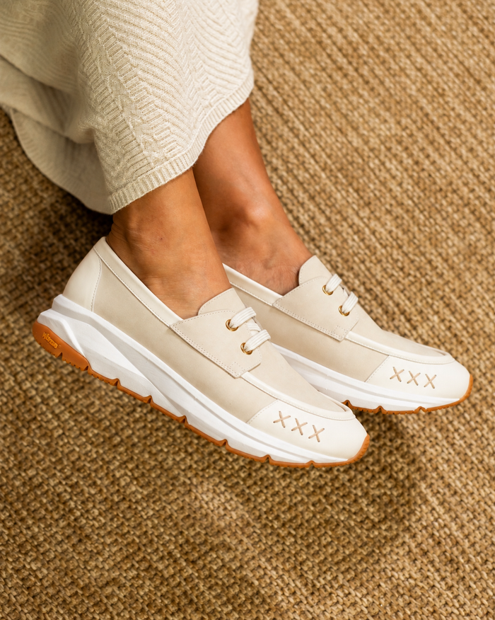 Mocassin Quai 19 modèle 3019 en cuir crème à semelle blanche, porté avec une jupe en maille ivoire